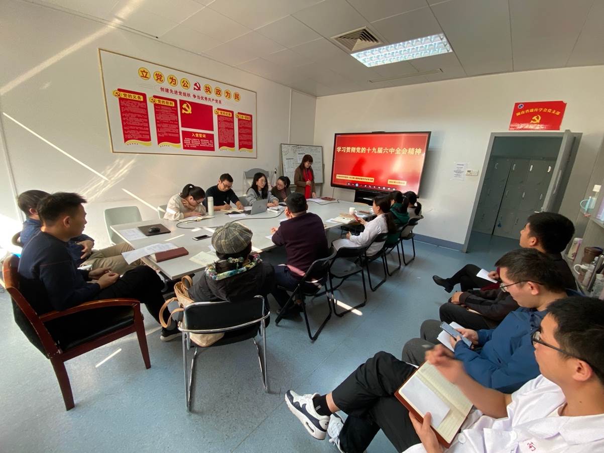 A group of people sitting in a room Description automatically generated with low confidence