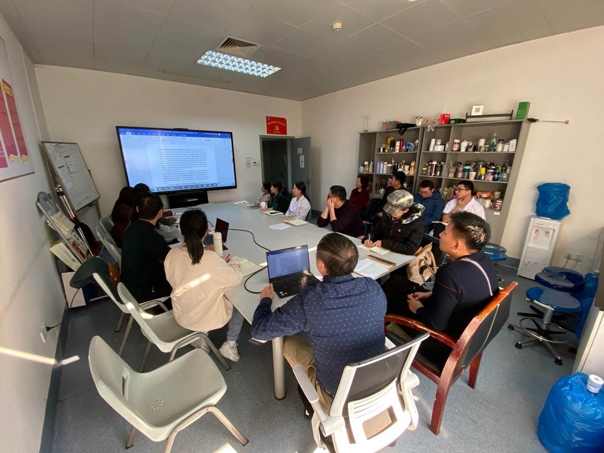 A group of people sitting around a table with laptops Description automatically generated with medium confidence